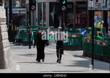 Le donne indossano maschere facciali mentre camminano nel centro di Londra mentre il blocco a livello nazionale del Regno Unito per rallentare la diffusione della malattia di Coronavirus continua per la settima settimana il 07 maggio 2020 a Londra, Inghilterra. Domenica, il primo ministro Boris Johnson è disposto ad annunciare misure per allentare alcune delle restrizioni di blocco a partire dalla prossima settimana, poiché il numero di vittime del codice 19 del Regno Unito ha superato i 30.000, il che lo rende il paese più colpito d'Europa. (Foto di Wiktor Szymanowicz/NurPhoto) Foto Stock