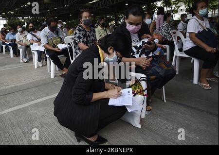 Il personale che indossa una maschera protettiva aiuta le persone thailandesi a chiedere di ricevere 5.000 baht thailandese (150 USD) assistenza finanziaria per coloro il cui reddito è influenzato dal COVID-19 coronavirus focolaio, a Bangkok, Thailandia 08, maggio 2020. (Foto di Anusak Laowilas/NurPhoto) Foto Stock