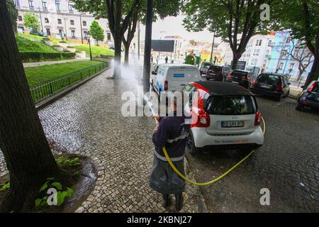 Un team di igiene urbana si lava con ipoclorito di sodio le strade del quartiere Estrela di Lisbona considerate più critiche, come le aree turistiche e fortemente popolate, anche quelle associate a interfacce di trasporto, ristoranti e altri punti commerciali. 10 maggio, 2020. Nonostante l'abolizione delle misure di emergenza che limitano il transito libero e l'imposizione di una quarantena obbligatoria, le istituzioni del governo portoghese continuano a realizzare i loro progetti di sostegno ai cittadini di fronte all'anticipo del COVID-19. Il Consiglio comunitario di Estrela è stato un Foto Stock