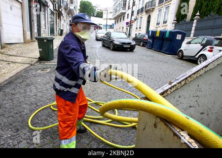 Un team di igiene urbana si lava con ipoclorito di sodio le strade del quartiere Estrela di Lisbona considerate più critiche, come le aree turistiche e fortemente popolate, anche quelle associate a interfacce di trasporto, ristoranti e altri punti commerciali. 10 maggio, 2020. Nonostante l'abolizione delle misure di emergenza che limitano il transito libero e l'imposizione di una quarantena obbligatoria, le istituzioni del governo portoghese continuano a realizzare i loro progetti di sostegno ai cittadini di fronte all'anticipo del COVID-19. Il Consiglio comunitario di Estrela è stato un Foto Stock