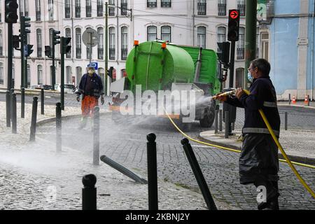 Un team di igiene urbana si lava con ipoclorito di sodio le strade del quartiere Estrela di Lisbona considerate più critiche, come le aree turistiche e fortemente popolate, anche quelle associate a interfacce di trasporto, ristoranti e altri punti commerciali. 10 maggio, 2020. Nonostante l'abolizione delle misure di emergenza che limitano il transito libero e l'imposizione di una quarantena obbligatoria, le istituzioni del governo portoghese continuano a realizzare i loro progetti di sostegno ai cittadini di fronte all'anticipo del COVID-19. Il Consiglio comunitario di Estrela è stato un Foto Stock