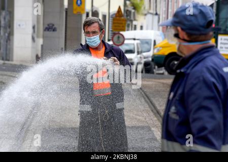 Un team di igiene urbana si lava con ipoclorito di sodio le strade del quartiere Estrela di Lisbona considerate più critiche, come le aree turistiche e fortemente popolate, anche quelle associate a interfacce di trasporto, ristoranti e altri punti commerciali. 10 maggio, 2020. Nonostante l'abolizione delle misure di emergenza che limitano il transito libero e l'imposizione di una quarantena obbligatoria, le istituzioni del governo portoghese continuano a realizzare i loro progetti di sostegno ai cittadini di fronte all'anticipo del COVID-19. Il Consiglio comunitario di Estrela è stato un Foto Stock