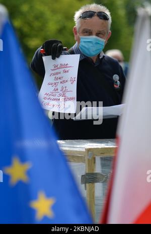 Un attivista del Comitato per la Difesa della democrazia (KOD) esprime il suo voto durante una finta elezione al Blonia Park di Cracovia. Le elezioni si sono svolte oggi, ma sono state sospese in seguito a un dibattito su come e quando si poteva votare in modo sicuro durante la pandemia di coronavirus. Il governo aveva proposto un voto a carattere postale, ma le critiche al piano e i complicati preparativi hanno portato al rinvio annunciato solo mercoledì scorso. Domenica 10 maggio 2020 a Cracovia, Polonia. (Foto di Artur Widak/NurPhoto) Foto Stock