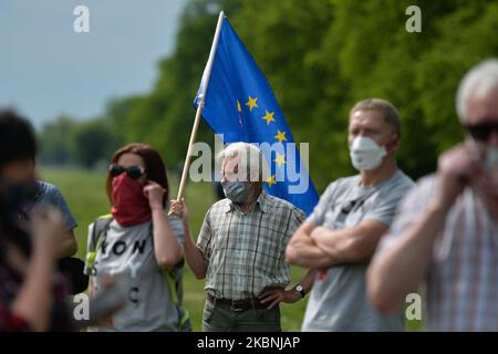 An activist from the Committee for the Defence of Democracy (KOD) holds an EU flag during a mock election at Krakow's Blonia Park. The election was set to take place today, but was suspended following debate over how and when voting could be done safely during the coronavirus pandemic. The government had proposed an all-postal vote, but criticism of the plan and infighting complicated preparations and led to the postponement announced only last Wednesday. On Sunday, May 10, 2020, in Krakow, Poland. (Photo by Artur Widak/NurPhoto) Stock Photo