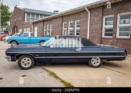 Des Moines, IA - 01 luglio 2022: Vista laterale in prospettiva alta di una Chevrolet Impala Convertibile 1964 ad una fiera di automobili locale. Foto Stock