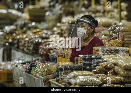 Mercanti di mercato che indossano maschera facciale e scudo mentre attende i clienti in mezzo alla malattia di coronavirus (COVID-19) pandemia nel mercato tradizionale di Denpasar, Bali, Indonesia il 15 2020 maggio. Il governo della città ha annunciato protocolli sanitari che ogni mercante deve indossare maschera, visiera protettiva e guanti per prevenire la diffusione della malattia di coronavirus. (Foto di Johanes Christo/NurPhoto) Foto Stock