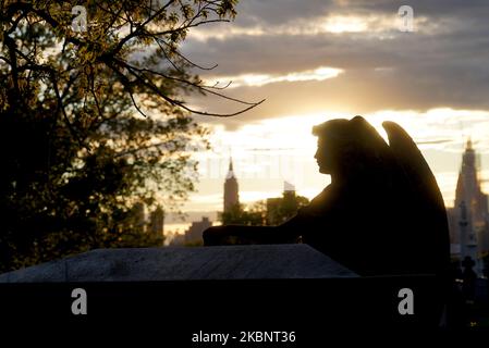 Le lapidi sono viste in un cimitero di New York City sullo sfondo dei grattacieli di Manhattan, Stati Uniti il 13 maggio 2020. (Foto di Selcuk Acar/NurPhoto) Foto Stock