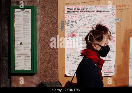 Una donna che indossa una maschera facciale passa davanti a un poster su cui le persone hanno scritto le loro speranze per come vogliono che il mondo sia diverso 'quando tutto questo è finito', fissato a lenzuola di legno su Shaftesbury Avenue a Londra, Inghilterra, il 15 maggio 2020. Sono ormai trascorse quasi otto settimane intere da quando il primo ministro britannico Boris Johnson ordinò il blocco del coronavirus del paese il 23 marzo, sebbene in tutta l'Inghilterra alcune delle misure, tra cui la restrizione all'esercizio all'aperto più di una volta al giorno, siano state rimosse questa settimana. (Foto di David Cliff/NurPhoto) Foto Stock