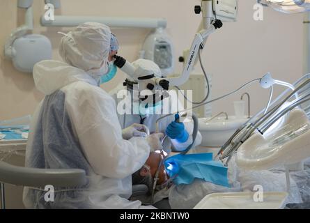 Un dentista e il suo assistente che indossa i DPI frequentano un paziente presso il Dentima Specialized Dental Center di Cracovia. Venerdì 15 maggio 2020 a Cracovia, Polonia. (Foto di Artur Widak/NurPhoto) Foto Stock