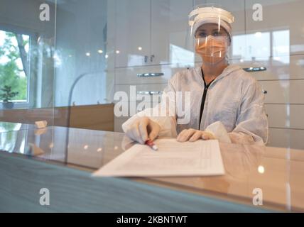 A receptionist wearing PPE at Dentima Specialized Dental Center in Krakow. On Friday, May 15, 2020, in Krakow, Poland. (Photo by Artur Widak/NurPhoto) Stock Photo