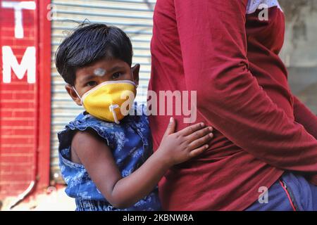 Una ragazza che indossa una maschera tiene suo padre mentre cavalcano una bicicletta in mezzo al coronavirus COVID-19 a Nuova Delhi, India il 16 maggio 2020 (Foto di Nasir Kachroo/NurPhoto) Foto Stock