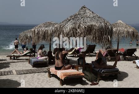 La gente gode della spiaggia nella periferia sud di Atene, durante il primo giorno della riapertura ufficiale delle spiagge al pubblico, ad Atene il 16 maggio 2020. Circa 515 spiagge riaprono da maggio 16 con l'applicazione di severe misure di allontanamento sociale per combattere la diffusione della pandemia COVID-19. (Foto di Panayotis Tzamaros/NurPhoto) Foto Stock