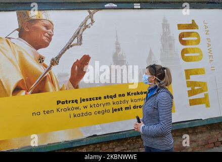 Una donna cammina accanto a un poster di Jean Paolo II nel centro di Cracovia. Karol Wojtyla, 18 maggio 1920 1978 – 2 2005 aprile 2005, è stato un . Prima, dal 1964 al 1974, fu arcivescovo di Cracovia. Sabato 16 maggio 2020 a Cracovia, Polonia. (Foto di Artur Widak/NurPhoto) Foto Stock