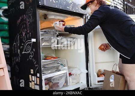 Una vista di una persona che immagazzina in su il frigorifero libero del cibo di Knickerbocker a Brooklyn che offre le merci congelate, la frutta fresca e la verdura, i libri ed i pannolini durante la pandemia del coronavirus il 16 maggio 2020 a New York City. Il COVID-19 si è diffuso nella maggior parte dei paesi del mondo, mietendo oltre 308.000 vittime e riportando oltre 4,6 milioni di infezioni. (Foto di John Nacion/NurPhoto) Foto Stock