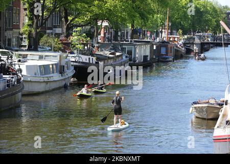 Gli abitanti del luogo si divertono in barca, in canoa e in pagaia presso il canale Brouwersgracht durante le giornate di sole in mezzo alla pandemia di Coronavirus il 17 maggio 2020 ad Amsterdam, Paesi Bassi. Il municipio di Amsterdam riapre oggi i canali dopo che è stato imposto il divieto di navigazione per ogni fine settimana, a causa della lenta flessibilizzazione della misura corona. (Foto di Paulo Amorim/NurPhoto) Foto Stock