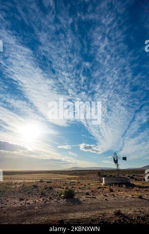 Mulino a vento (pompa a vento) in una scena rurale di Roggeveld che mostra splendide formazioni di nuvole. Vicino a Sutherland, Northern Cape. Sudafrica, Foto Stock