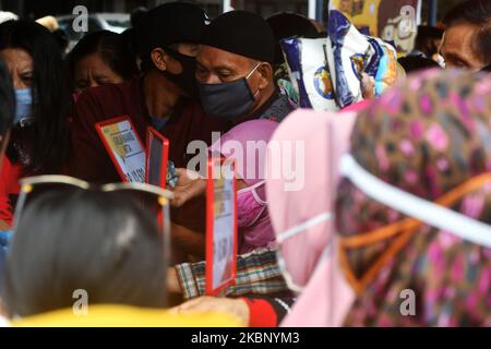 I residenti acquistano prodotti alimentari che vengono venduti all'apertura di un mercato a buon mercato a Palu, nella Provincia Centrale di Sulawesi, Indonesia, il 18 maggio 2020. Il mercato è detenuto dal governo locale ogni anno poco prima di Lebaran e la vendita di ingredienti alimentari a prezzi bassi è imballato con residenti anche se il virus corona è pandemico (COVID-19). (Foto di Mohamad Hamzah/NurPhoto) Foto Stock