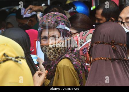 I residenti acquistano prodotti alimentari che vengono venduti all'apertura di un mercato a buon mercato a Palu, nella Provincia Centrale di Sulawesi, Indonesia, il 18 maggio 2020. Il mercato è detenuto dal governo locale ogni anno poco prima di Lebaran e la vendita di ingredienti alimentari a prezzi bassi è imballato con residenti anche se il virus corona è pandemico (COVID-19). (Foto di Mohamad Hamzah/NurPhoto) Foto Stock