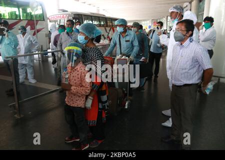 Un piccolo ragazzo passeggero con la copertura del viso grad con la madre check-out il Netaji Subhash Chandra Bose International Airport dopo aver portato dal Bangladesh in un volo speciale sotto la missione Vande Bharat durante un blocco a livello nazionale imposto come misura preventiva contro il coronavirus COVID-19 a Kolkata il mese di maggio 18,2020 in India. Il volo ha trasportato 169 persone, di cui 16 bisognose di cure mediche di emergenza e una donna incinta . (Foto di Debajyoti Chakraborty/NurPhoto) Foto Stock