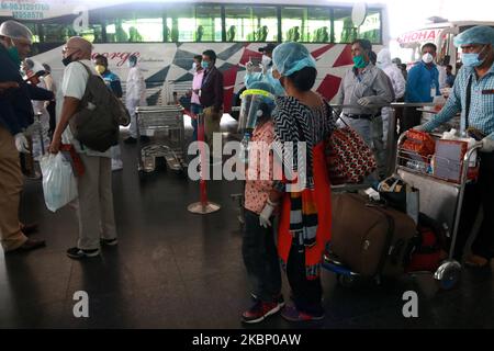 Un piccolo ragazzo passeggero con la copertura del viso grad con la madre check-out il Netaji Subhash Chandra Bose International Airport dopo aver portato dal Bangladesh in un volo speciale sotto la missione Vande Bharat durante un blocco a livello nazionale imposto come misura preventiva contro il coronavirus COVID-19 a Kolkata il mese di maggio 18,2020 in India. Il volo ha trasportato 169 persone, di cui 16 bisognose di cure mediche di emergenza e una donna incinta . (Foto di Debajyoti Chakraborty/NurPhoto) Foto Stock