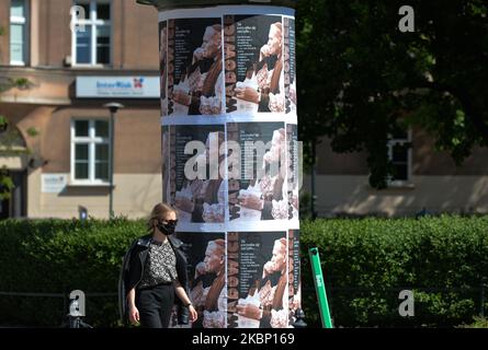 Una giovane donna passa per manifesti con Jen Paolo II davanti all'Istituto della memoria Nazionale di Cracovia. In occasione del 100th° anniversario della nascita di Giovanni Paolo II, l’IPN ha presentato un portale sulle visite pastorali del Papa Giovanni Paolo II nella sua patria durante la Repubblica popolare Polacca. Lunedì 18 maggio 2020 a Cracovia, Polonia. (Foto di Artur Widak/NurPhoto) Foto Stock