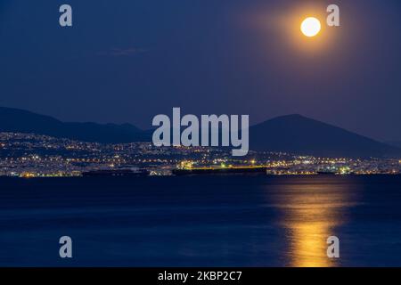 Lo scintillante Super Flower Moon del maggio 2020, visto che sorge sul Mar Egeo e sulla città di Salonicco in Grecia da Kalochori il 7 maggio 2020. L'ascesa dell'ultima superluna del 2020 appare sulle colline della città di Salonicco, brilla nel cielo greco-mediterraneo e si riflette sul mare illuminando la notte oscura. (Foto di Nicolas Economou/NurPhoto) Foto Stock