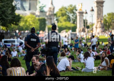 I parigini godono del sole a Parigi, in Francia, il 21 maggio 2020. Meno di una settimana dopo la fine del blocco, causa del coronavirus, covid-19 epidemia, i parisiens stanno cominciando a vivere di nuovo.mentre la lunga fine settimana di ascensione sta iniziando, il tempo si sente come l'estate, la gente a Parigi godere il sole vicino al fiume, La Senna, sull'erba come vicino luogo di Invalides, ma la polizia è qui per controllare se è troppo affollata, o se le persone non sono troppo chiuse. (Foto di Jerome Gilles/NurPhoto) Foto Stock