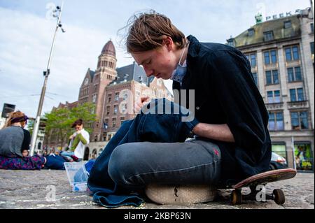 Un attivista XR sta cucendo abiti usati, durante un'azione XR contro l'industria della moda veloce ad Amsterdam, il 22nd maggio 2020. (Foto di Romy Arroyo Fernandez/NurPhoto) Foto Stock