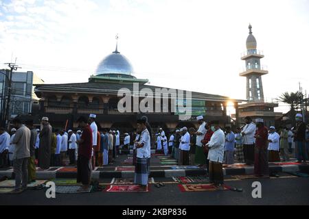 I musulmani indonesiani eseguono le preghiere di Eid al-Fitr indossando maschere e mantenendo la loro distanza sulle file all'interno e all'esterno del cortile della moschea di Jami 'Annur, Kranji, Bekasi, Giava Occidentale il 24,2020 maggio. Il governo ha eseguito preghiere Eid nel 2020 per effettuare nelle loro rispettive case per rompere la catena di distribuzione di Covid-19, ma ci sono ancora molte persone che tengono preghiere Eid nelle moschee a causa della fine delle restrizioni sociali su larga scala (PFB) nelle loro rispettive regioni. Dasril Roszandi (Foto di Dasril Roszandi/NurPhoto) Foto Stock