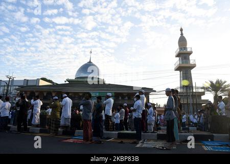 I musulmani indonesiani eseguono le preghiere di Eid al-Fitr indossando maschere e mantenendo la loro distanza sulle file all'interno e all'esterno del cortile della moschea di Jami 'Annur, Kranji, Bekasi, Giava Occidentale il 24,2020 maggio. Il governo ha eseguito preghiere Eid nel 2020 per effettuare nelle loro rispettive case per rompere la catena di distribuzione di Covid-19, ma ci sono ancora molte persone che tengono preghiere Eid nelle moschee a causa della fine delle restrizioni sociali su larga scala (PFB) nelle loro rispettive regioni. Dasril Roszandi (Foto di Dasril Roszandi/NurPhoto) Foto Stock