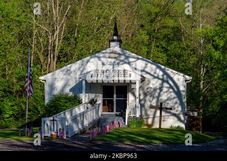 La luce del mattino colpisce una piccola chiesa locale con la bandiera americana a mezza altezza in onore di coloro che sono morti il Memorial Day in seguito alla pandemia di Coronavirus COVID-19, lunedì 25 maggio 2020, a Cincinnati, Ohio, Stati Uniti. (Foto di Jason Whitman/NurPhoto) Foto Stock