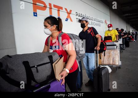 I lavoratori filippini stranieri di ritorno (OFW) fanno la coda fuori da un terminal mentre aspettano il loro giro in autobus che va alle loro province il 28 maggio 2020 a Parañaque City, Filippine. I filippini che desiderano tornare nelle loro province sono forniti di trasporto gratuito nell'ambito di un programma governativo.(Foto di Lisa Marie David/NurPhoto) Foto Stock