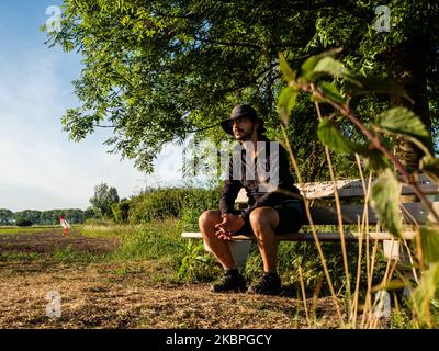 Un uomo sta prendendo una pausa seduto su una panchina vicino ad un campo asciutto nella zona del Ooijpolder a Nijmegen, il 31st maggio 2020. (Foto di Romy Arroyo Fernandez/NurPhoto) Foto Stock