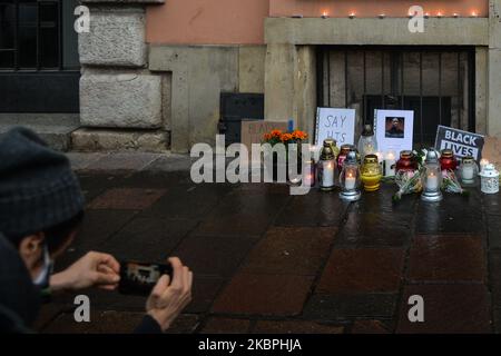 Un uomo scatta foto di messaggi, fiori e candele lasciate davanti a una foto di George Floyd, fuori dal Consolato degli Stati Uniti a Cracovia. Il 25 maggio a Minneapolis, l'uomo nero di 46 anni George Floyd è stato strangolato da un ufficiale di polizia. Era solo sospettato di usare un assegno falso. Molti residenti e stranieri si sono manifestati questa sera davanti al Consolato degli Stati Uniti per esprimere la loro solidarietà alla famiglia di Floyd, ai suoi cari e a centinaia di migliaia di americani che da diversi giorni escono per le strade delle loro città chiedendo giustizia. Domenica 31 maggio 2020 a Cracovia, Polonia. Foto Stock