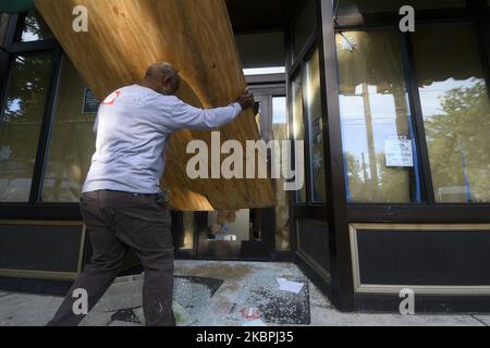 Un passerby salta volontariamente nel negozio di vino e liquori di proprietà statale dopo che è stato vandalizzato durante la notte, nel quartiere Mt Airy di Philadelphia, PA, il 1 giugno 2020. Lunedì mattina sono arrivate le truppe della Guardia Nazionale per assistere le forze di polizia della città dopo due giorni di disordini e proteste per la morte di George Floyd. (Foto di Bastiaan Slabbers/NurPhoto) Foto Stock