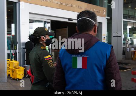 Un membro dell'Ambasciata d'Italia e un ufficiale di polizia colombiana custodisca la porta dove residenti italiani e rumeni si sono arenati in Colombia in mezzo alla pandemia di Coronavirus aspettano all'Aeroporto di El Dorado il loro volo umanitario per imbarcarsi il 2 giugno 2020 a Bogotà, Colombia. (Foto di Sebastian Barros/NurPhoto) Foto Stock