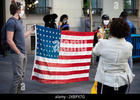 Due americani detengono una bandiera statunitense con i nomi di coloro che sono stati uccisi dalla polizia di fronte all'Ambasciata degli Stati Uniti in Spagna, Madrid, 7 giugno 2020, nella protesta confonduta da gruppi afro-discendenti a Madrid, a sostegno della comunità afro-americana. . (Foto di Jon Imanol Reino/NurPhoto) Foto Stock