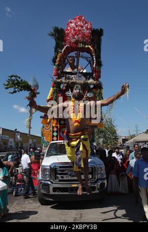 Il devoto indù Tamil esegue il rituale para-kavadi mentre è sospeso da ganci spinti nella sua schiena e gambe e rimbalzato su e giù come atto di penitenza durante il Vinayagar Ther Thiruvizha Festival in Ontario, Canada. (Foto di Creative Touch Imaging Ltd./NurPhoto) Foto Stock