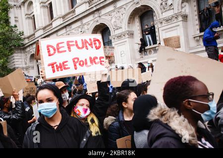 Un manifestante porta un cartello che sostiene le richieste di 'definanziare la polizia' come attivisti della Black Lives Matter, riuniti per il secondo giorno consecutivo di protesta di massa contro il razzismo, dimostreranno a Londra, in Inghilterra, il 7 giugno 2020. Oggi ha segnato la quarta massiccia protesta Black Lives Matter a Londra in otto giorni, in un’ondata globale di manifestazioni antirazziste scatenate dall’uccisione in custodia di polizia di un uomo nero, George Floyd, nella città statunitense di Minneapolis il 25 maggio. (Foto di David Cliff/NurPhoto) Foto Stock