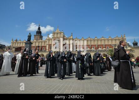 Membri di diversi ordini religiosi cattolici visti durante una processione del Corpus Christi guidata dall'arcivescovo Marek Jedraszewski nella piazza principale del mercato di Cracovia. La festa del Corpus Domini, detta anche solennità del Santissimo corpo e sangue di Cristo, è una solennità liturgica cattolica che celebra la presenza reale del corpo e del sangue, dell'anima e della Divinità di Gesù Cristo negli elementi dell'Eucaristia. Il 11 giugno 2020, a Cracovia, Polonia. (Foto di Artur Widak/NurPhoto) Foto Stock