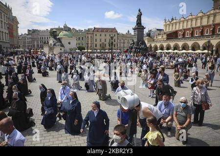 I cattolici celebrano il Corpus Domini partecipando alla Santa Messa e alla processione durante la diffusione del coronavirus. Cracovia, Polonia il 11 giugno 2020. La processione inizia con un sacerdote che porta un mostrania sotto un baldacchino. I fedeli lo seguono cantando inni religiosi, mentre le giovani ragazze vestite con abiti bianchi o tradizionali regionali spargono petali di fiori lungo il percorso. Il Corpus Christi è una festa cattolica mobile che commemora la Transostituzione. (Foto di Beata Zawrzel/NurPhoto) Foto Stock