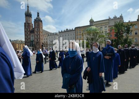 Membri di diversi ordini religiosi cattolici visti durante una processione del Corpus Christi guidata dall'arcivescovo Marek Jedraszewski nella piazza principale del mercato di Cracovia. La festa del Corpus Domini, detta anche solennità del Santissimo corpo e sangue di Cristo, è una solennità liturgica cattolica che celebra la presenza reale del corpo e del sangue, dell'anima e della Divinità di Gesù Cristo negli elementi dell'Eucaristia. Il 11 giugno 2020, a Cracovia, Polonia. (Foto di Artur Widak/NurPhoto) Foto Stock