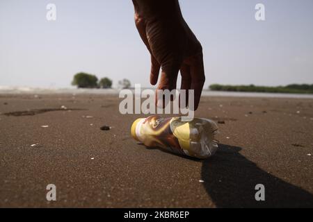 Un uomo raccoglie i rifiuti di bottiglie di plastica lasciati dal turista sulla spiaggia a Pantai Bahagia, distretto di Muara Gembong, bekasi regency, provincia di Giava Ovest, il 13 giugno, 2020. Secondo i rapporti di ricerca dell'Istituto indonesiano delle scienze (LIPI), pubblicati nel 2018, la quantità di rifiuti di plastica nel mare indonesiano raggiunge le 100,000 - 400,000 tonnellate all'anno, con una distribuzione costiera media di circa 1,71 pezzi per metro quadrato con un peso medio di 46,55 grammi per metro quadrato. Mentre il più alto spreco medio di plastica è stato trovato sulla costa di Sulawesi, raggiungendo 2,11 pezzi per piazza Foto Stock