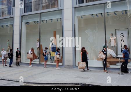 Shoppers queue along New Bond Street to enter the Oxford Street branch of clothing retailer Zara in London, England, on June 15, 2020. Non-essential retail stores across England have today been allowed to open for the first time since the coronavirus lockdown was imposed back in March. In central London, shoppers were out in force this afternoon, with queues outside many stores due to social distancing requirements within. (Photo by David Cliff/NurPhoto) Foto Stock