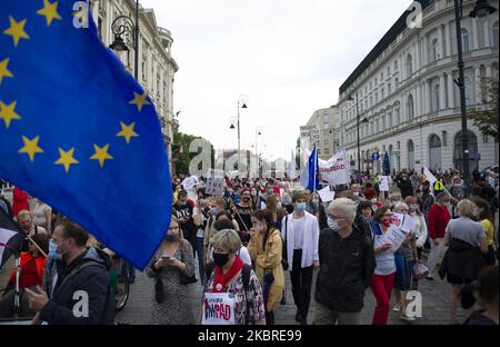 Demonstrators march next to the presidential palace (not pictured) during an anti-government protest on June 20, 2020 in Warsaw, Poland. Several hundreds of demonstrators took the streets in a peaceful protest against the ruling party Law and Justice (PiS) bringing together different opposition groups. Amongst them the Democracy Defence Committee (Komitet Obrony Demokracji), All-Poland Women Strike (Ogolnopolski Strajk Kobiet), Students Antifascists Committee (Studentski Komitet Antyfaszystowski), All-Poland Civic Strike (Ogolnopolski Strajk Obywatelski) and the Union Alternative (Zwiazkowa Al Stock Photo