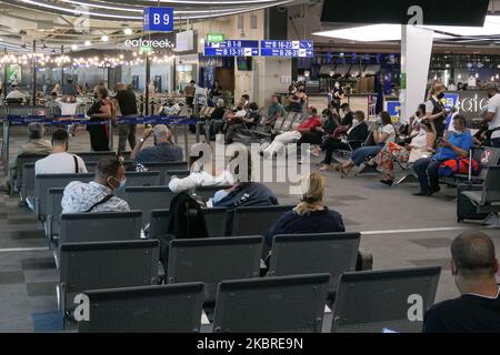 Passeggeri visti con le maschere facciali obbligatorie all'aeroporto internazionale ATH LGAV di Atene, in Grecia, il 18 giugno 2020, dopo la quarantena di Coronavirus e le restrizioni di viaggio. I passeggeri che indossano maschere e guanti, utilizzano disinfettanti per le mani come misura preventiva contro la diffusione della pandemia COVID-19. La Grecia e l'Europa hanno chiuso a lungo le frontiere per le persone al di fuori dell'Europa e della zona Schengen, ma la Grecia ha iniziato a revocare il divieto di circolazione dal 15 giugno 2020 per i paesi della zona Schengen e il 1 luglio 2020 si arriverà a un maggiore allentamento. I passeggeri in arrivo sono soggetti al decor Foto Stock