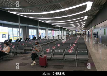 Passeggeri visti con le maschere facciali obbligatorie all'aeroporto internazionale ATH LGAV di Atene, in Grecia, il 18 giugno 2020, dopo la quarantena di Coronavirus e le restrizioni di viaggio. I passeggeri che indossano maschere e guanti, utilizzano disinfettanti per le mani come misura preventiva contro la diffusione della pandemia COVID-19. La Grecia e l'Europa hanno chiuso a lungo le frontiere per le persone al di fuori dell'Europa e della zona Schengen, ma la Grecia ha iniziato a revocare il divieto di circolazione dal 15 giugno 2020 per i paesi della zona Schengen e il 1 luglio 2020 si arriverà a un maggiore allentamento. I passeggeri in arrivo sono soggetti al decor Foto Stock