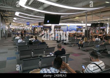 Passeggeri visti con le maschere facciali obbligatorie all'aeroporto internazionale ATH LGAV di Atene, in Grecia, il 18 giugno 2020, dopo la quarantena di Coronavirus e le restrizioni di viaggio. I passeggeri che indossano maschere e guanti, utilizzano disinfettanti per le mani come misura preventiva contro la diffusione della pandemia COVID-19. La Grecia e l'Europa hanno chiuso a lungo le frontiere per le persone al di fuori dell'Europa e della zona Schengen, ma la Grecia ha iniziato a revocare il divieto di circolazione dal 15 giugno 2020 per i paesi della zona Schengen e il 1 luglio 2020 si arriverà a un maggiore allentamento. I passeggeri in arrivo sono soggetti al decor Foto Stock