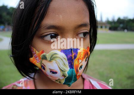 Un bambino è visto indossare una maschera mentre vive una nuova vita normale in mezzo a una pandemia co-19 mentre viaggia con la sua famiglia in Piazza Merdeka, Medan, Provincia di Sumatra Nord, Indonesia, Lunedi, Giugno 22, 2020. (Foto di Panyahatan Siregar/NurPhoto) Foto Stock