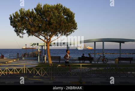 Sunset illuminates a man who plays sports on the waterfront. Limassol, Cyprus, Tuesday, June 23, 2020 The Ministry of Health of Cyprus from June 24 repeals the rule limiting meetings to a maximum of 10 people. Thus, since June 24, the maximum allowed number of participants for meetings in closed rooms is 75 people, for open rooms - 150 people. This rule applies to wedding ceremonies, christenings, concerts, festivals, private gatherings in houses (in this case, the owners of the house are also considered participants) and to all other forms of mass gatherings. Larger and more numerous events a Foto Stock